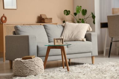 Oturma odasının içi. Masada kanepe ve küp takvimi var.