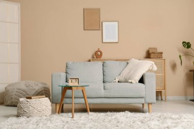 Oturma odasının içi. Masada kanepe ve küp takvimi var.