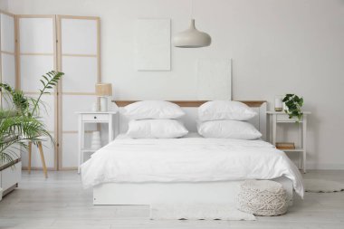 Beyaz çarşaflı, beyaz perdeli ve masalı aydınlatma odasının içinde.