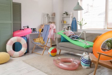 Oturma odasındaki kanepede plaj aksesuarlarıyla insan iskeleti.