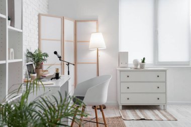 Podcaster 'ın atölyesinin içinde iş yeri, katlanan ekran ve parlayan lamba var.