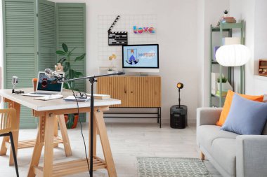 Podcaster 'ın atölyesinin içinde çalışma yeri ve kanepesi var.