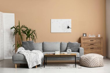 Oturma odasının içi. Masada kanepe ve küp takvimi var.