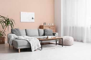 Oturma odasının içi. Masada kanepe ve küp takvimi var.