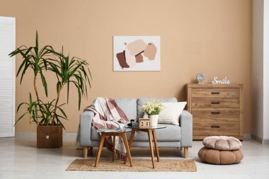 Oturma odasının içinde kanepe, masa ve küp takvimi var.