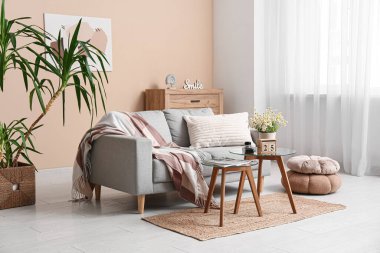 Oturma odasının içinde kanepe, masa ve küp takvimi var.