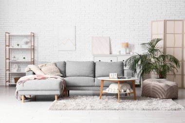 Oturma odasının içi. Masada kanepe ve küp takvimi var.