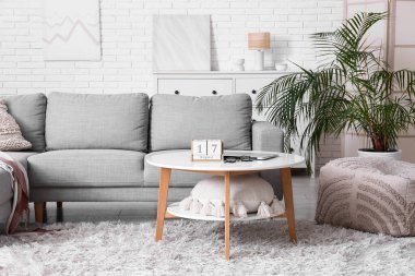 Oturma odasının içi. Masada kanepe ve küp takvimi var.