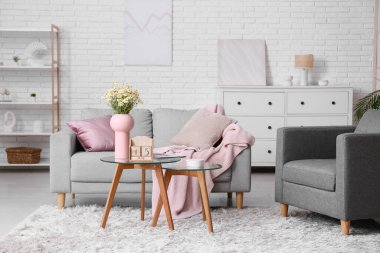 Oturma odasının içinde kanepe, masa ve küp takvimi var.