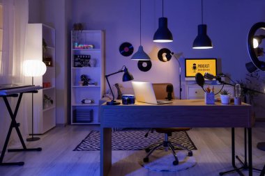 Karanlık Podcaster 'ın atölyesinin içinde iş yeri ve parlak lambalar var.