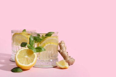 Zencefil ve fesleğenle doldurulmuş taze limonlu su bardakları.