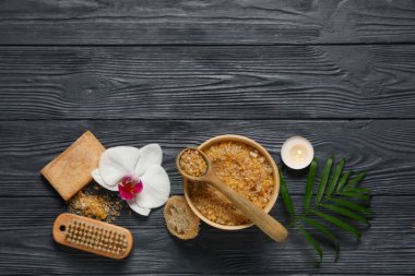 Siyah ahşap arka planda deniz tuzu, mum ve banyo malzemeleriyle güzel bir spa kompozisyonu.