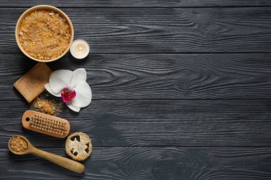 Siyah ahşap arka planda deniz tuzu, mum ve banyo malzemeleriyle güzel bir spa kompozisyonu.
