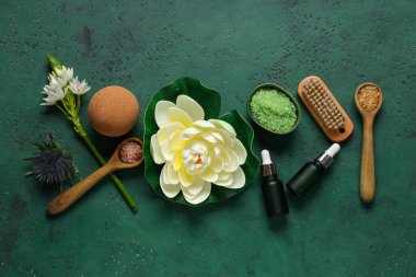 Güzel bir spa kompozisyonu, banyo malzemeleri, kase ve kaşık dolusu deniz tuzu yeşil grunge arka planda.