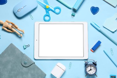 Mavi arka planda modern tablet bilgisayar ve okul malzemeleri ile kompozisyon