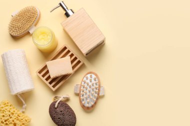 Bej arka planda masaj vücut fırçaları, sabun çubuğu, şişe ve kozmetik ürünler kavanozu ile kompozisyon, yakın plan