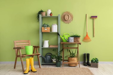 Bahçe aletleri, bitkiler ve sandalyeli atölyenin içi