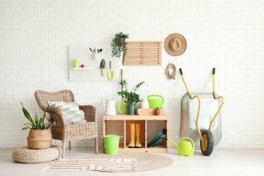 Bahçe aletleri, bitkiler ve koltuk ile atölyenin içi