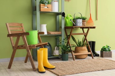 Bahçe aletleri, bitkiler ve sandalyeli atölyenin içi