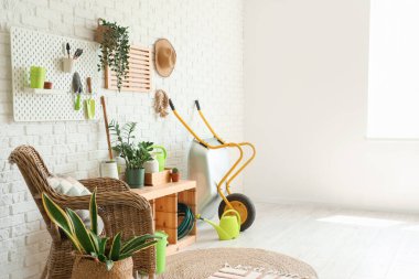 Bahçe aletleri, bitkiler ve koltuk ile atölyenin içi