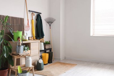 Bahçe aletleri, bitkiler ve raflı atölyenin içi