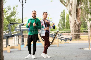 Genç Asyalı kadın ve spor sahasında ip atlayan kişisel antrenör.