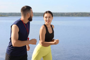 Nehir kıyısında spor eğitmeni olan Asyalı bir kadın.