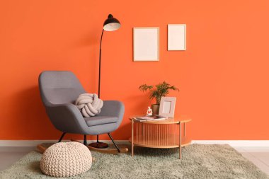 Sallanan sandalyesi, lambası ve masası olan şık bir oturma odası.