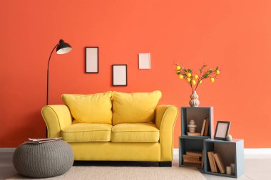 Sarı kanepesi, lambası ve kitaplığı olan şık bir oturma odası.