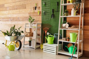 Raf üniteleri, bahçe aletleri ve pim tahtasıyla birlikte atölyenin içi