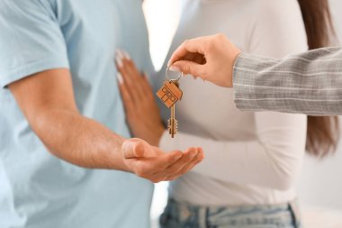 Genç çift yeni dairelerinde emlakçıdan anahtar alıyor.