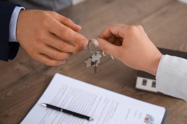 Genç adam yeni dairesinde emlakçıdan anahtar alıyor.