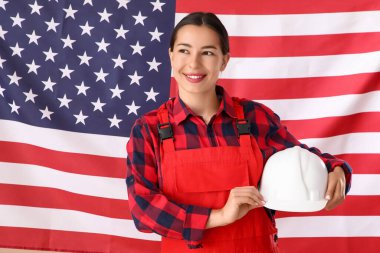 Amerikan bayrağına karşı sert şapkalı kadın işçi. İşçi Bayramı kutlamaları