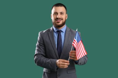 Yeşil arka planda ABD bayrağı taşıyan genç bir iş adamı. İşçi Bayramı kutlamaları