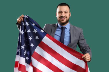 Yeşil arka planda ABD bayrağı taşıyan genç bir iş adamı. İşçi Bayramı kutlamaları