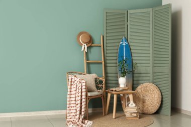 Oturma odası, koltuk, sehpa ve sörf tahtası.