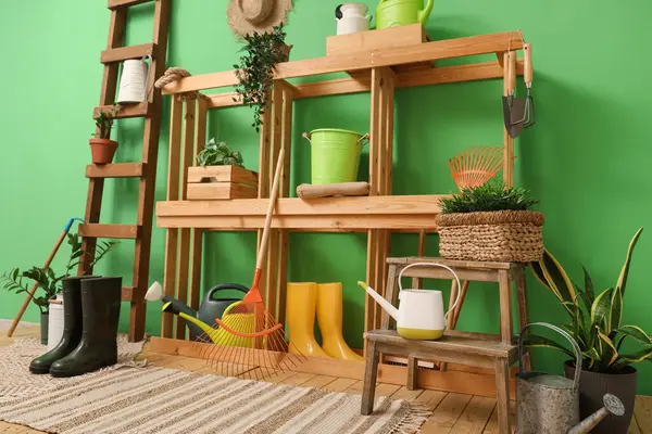 Bahçe aletleri, raf ünitesi ve merdiveni olan atölyenin içi