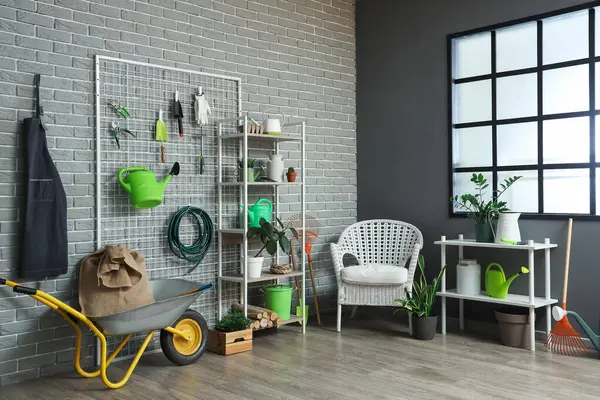 Raf üniteleri, bahçe aletleri ve koltuk ile atölyenin içi