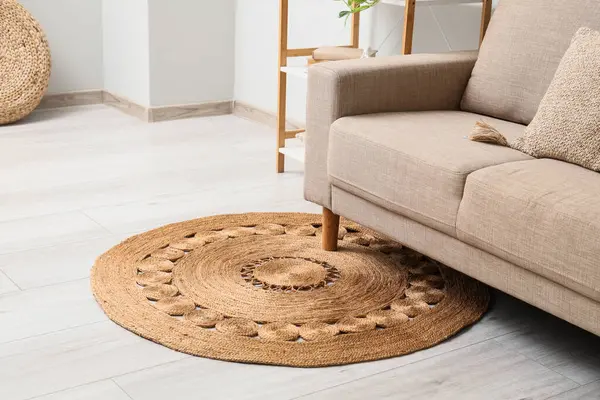 Oturma odasındaki hasır halıda gri kanepe