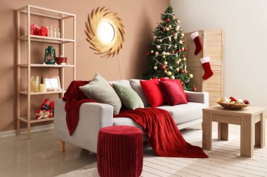 Oturma odasının içinde kanepe, masa ve Noel ağacı var.