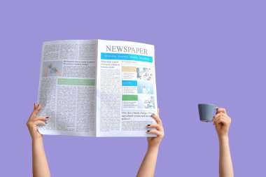 Gazete ve bir fincan kahveyle leylak arka planda bir kadın eli