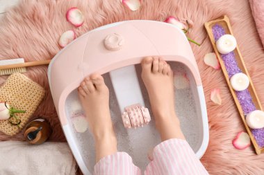 Ayak masajlı kadın bacakları ve yerde kaplıca malzemeleri, yakın plan.