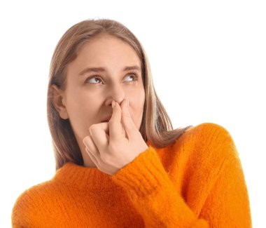 Genç bir kadın beyaz arka planda korkunç bir koku hissediyor.