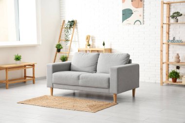 Kanepesi ve raf ünitesi olan modern oturma odasının şık bir iç mekanı.