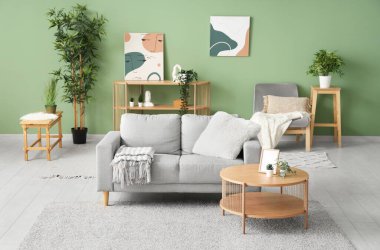 Renk duvarına yakın masa ve kanepesi olan modern oturma odasının içinde.