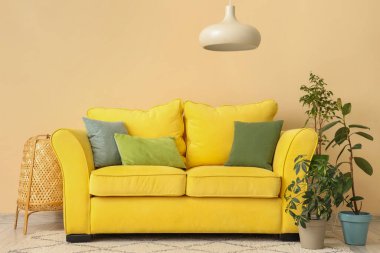 Sarı kanepeli ve çiçekli bej oturma odasının içi.