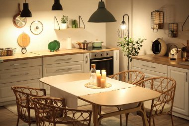 Parlayan lambaları, beyaz tezgahları ve akşamları sofrası olan modern mutfağın içinde.