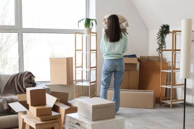 Taşındığı gün oturma odasında karton kutuları olan genç bir kadın.