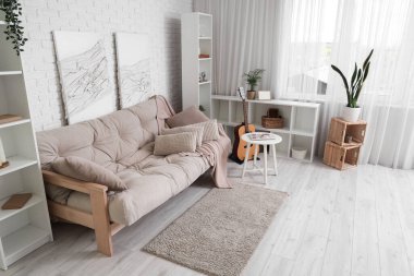 Rahat kanepesi, sehpası ve akustik gitarı olan güzel bir oturma odası.