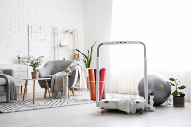 Hafif oturma odasında spor salonu ve spor paspasları olan koşu bandı.